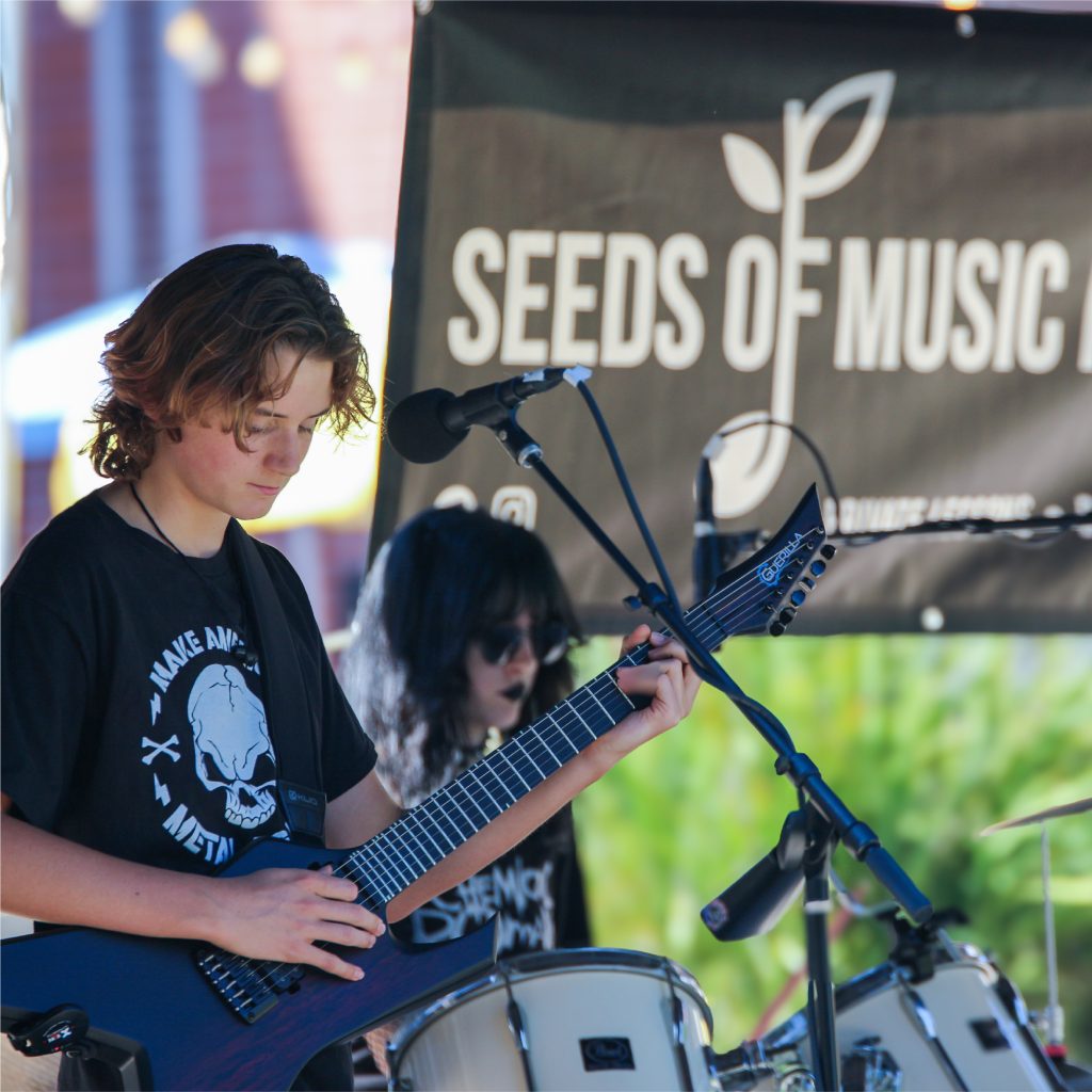 Kids in a rock band with a Seeds of Music Banner