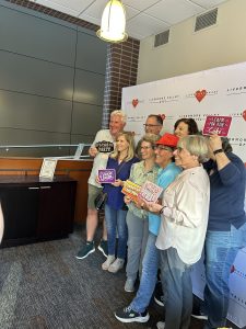 7 people standing in front of a step and repeat banner with the LVA logo for a photo booth photo.